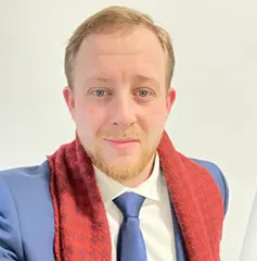 Man in suit and red scarf smiling